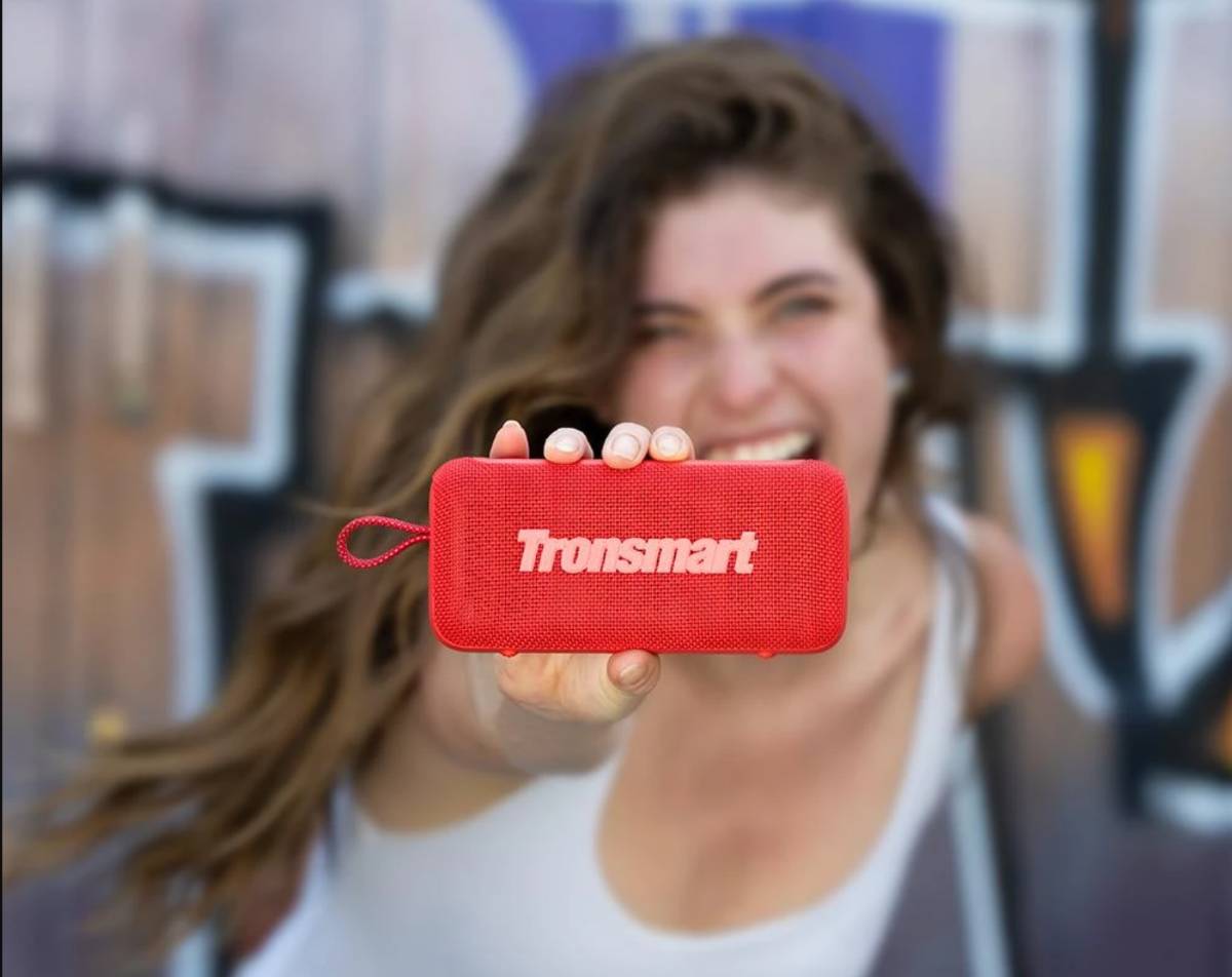 Egy nő tartja a kezében a piros Tronsmart Trip 2 hangszórót